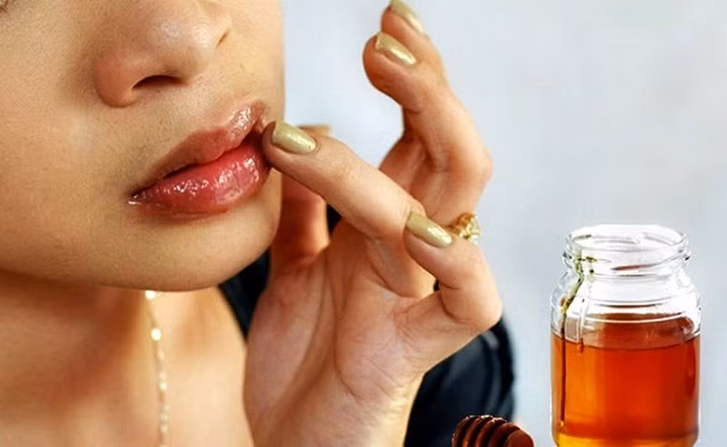 Cách thực hiện đơn giản: trộn đường với mật ong, thoa lên môi, massage nhẹ nhàng theo vòng tròn trong khoảng 1–2 phút, sau đó rửa sạch bằng nước ấm. Ảnh minh họa