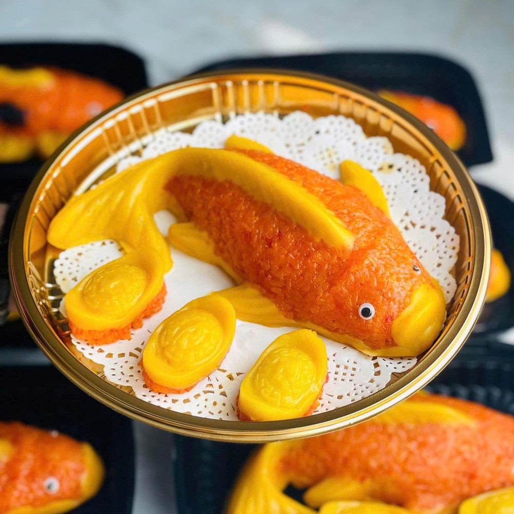 Trong mâm cúng, cá chép là lễ vật không thể thiếu, được xem là linh vật đưa các Táo vượt vũ môn lên thiên đình. Bên cạnh cá chép sống để phóng sinh, nhiều gia đình hiện nay còn chuẩn bị thêm xôi gấc tạo hình cá chép để dâng cúng. Đĩa xôi đỏ thắm tượng trưng cho may mắn, đủ đầy, vừa giữ nét truyền thống vừa mang tính thẩm mỹ cao. Ảnh minh họa