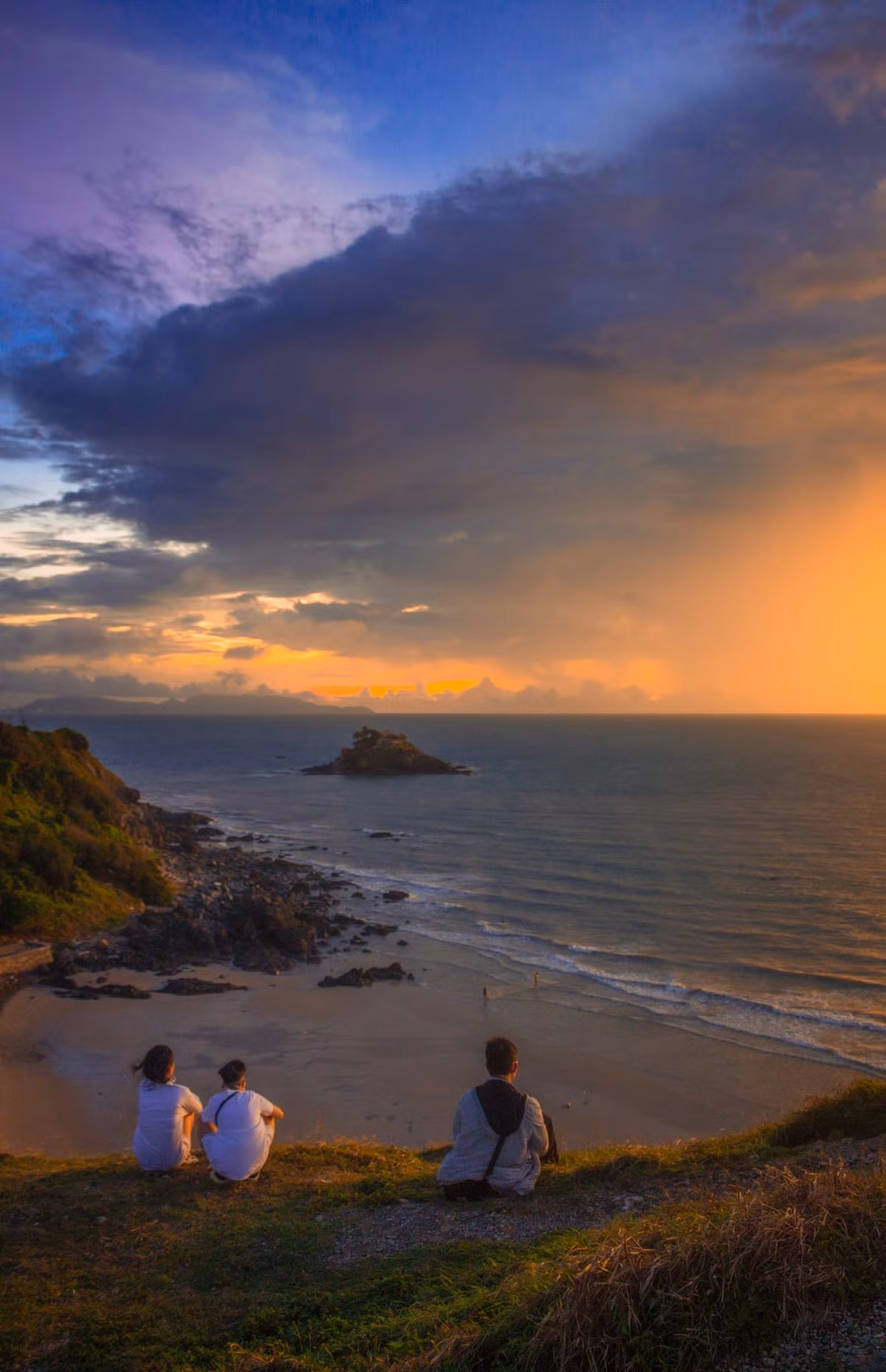 Mặt trời khi ấy như quả cầu đỏ rực, từ từ chìm xuống đường chân trời xa tít, để lại những vệt sáng cuối cùng óng ánh trên sóng biển. Không khí cũng dịu mát hơn, gió thổi nhẹ, mang theo mùi mặn mà của đại dương khiến ai cũng muốn thả mình trôi theo làn gió ấy, quên đi mọi bộn bề. Ảnh dulich