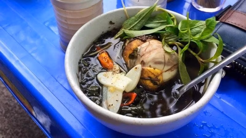 Đầu tiên phải kể đến trứng vịt lộn hầm ngải cứu – món ăn quen mà lạ. Cái đắng của ngải non quyện trong vị béo bùi của trứng và chút gừng cay khiến người ăn thấy ấm đến tận lòng. Nhiều quán còn hầm cùng xương để nước ngọt sâu, mùi thơm phảng phất trong làn khói sương của buổi chiều trở gió. Ảnh BHX