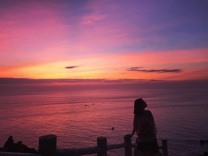 Bao quanh hải đăng là những vách đá dựng đứng, xếp chồng tự nhiên với hình thù độc đáo, tạo nên một khung cảnh vừa hùng vĩ vừa nên thơ. Phía dưới là biển xanh trong, xa xa là những dải cát uốn cong và thảm thực vật ven núi còn khá nguyên sơ. Ảnh luhanhvietnam