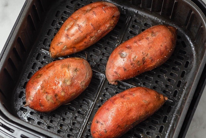 Với nhịp sống bận rộn, khoai lang nướng bằng nồi chiên không dầu được xem là lựa chọn tiện lợi. Chỉ cần rửa sạch, xăm nhẹ vỏ rồi cho vào nồi chiên ở nhiệt độ vừa phải, sau khoảng nửa giờ là đã có ngay món ăn nóng hổi. Ảnh minh họa