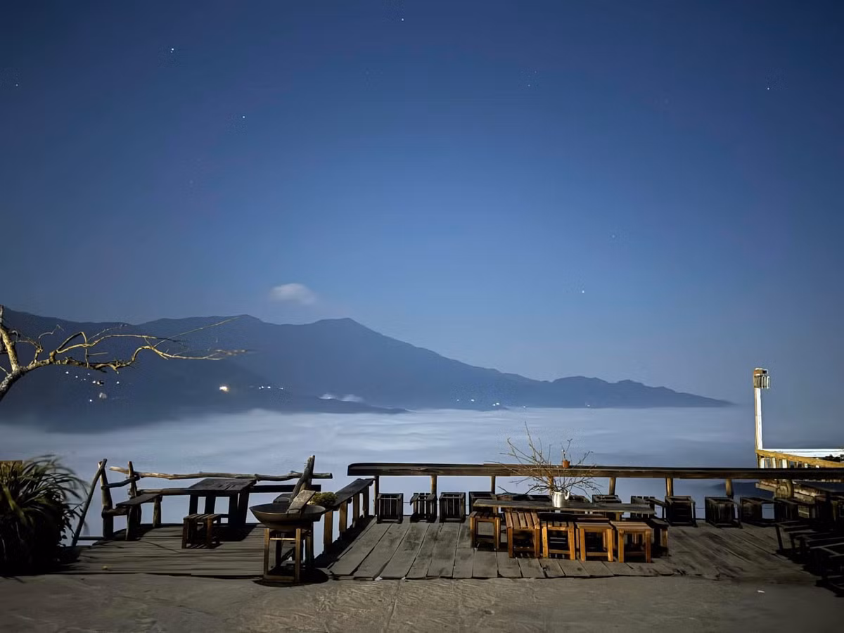 Thào Coffee là một trong những quán đầu tiên xuất hiện ở Tà Xùa, nằm ngay trung tâm xã. Quán gây ấn tượng với kiến trúc kết hợp giữa gỗ và đá, tạo nên không gian vừa mộc mạc, vừa ấm áp. Chiếc cổng gỗ hướng ra thung lũng – nơi mây trôi ngang tầm mắt – đã trở thành điểm check-in “huyền thoại” mà bất kỳ du khách nào cũng muốn dừng lại. Ảnh Thào Coffee Tà Xùa