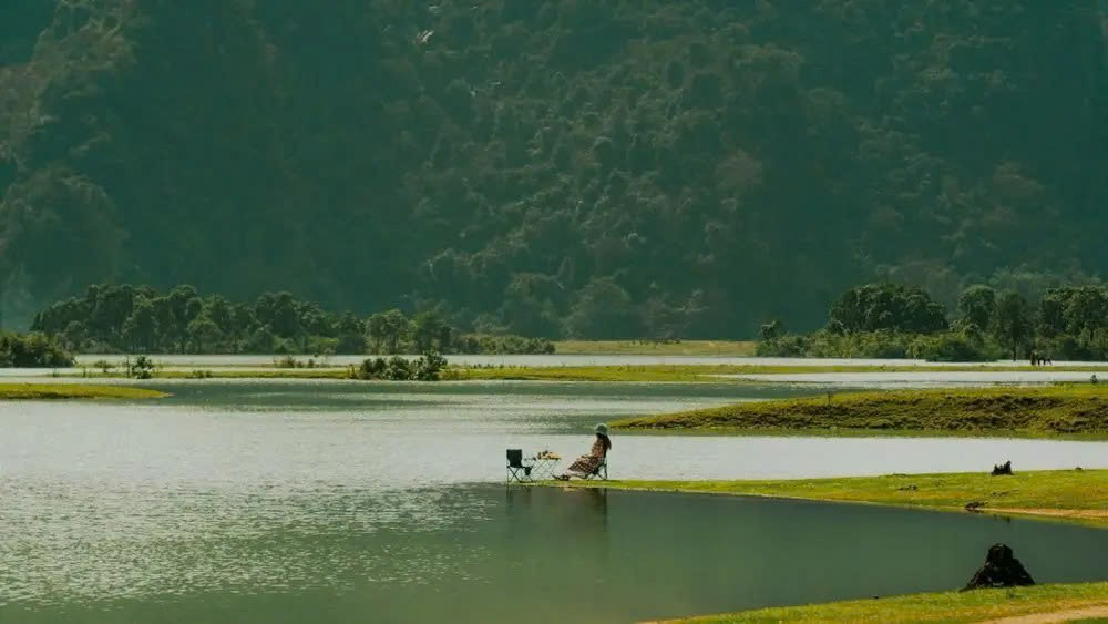 Mùa khô, Đồng Lâm là bãi cỏ lý tưởng để cắm trại. Đến mùa mưa, nước suối tràn về khiến nơi đây hóa hồ lớn, tạo nên khung cảnh nên thơ với mặt nước xanh, trâu lội thong dong và khói bếp mờ xa giữa núi rừng. Ảnh Traveloka