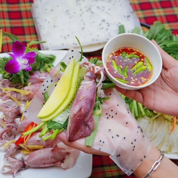 Mực sau khi làm sạch, bỏ túi mực và màng ngoài thì khứa nhẹ để thấm gia vị, ướp cùng muối, tiêu, gừng băm và bột ngọt khoảng 10–15 phút. Rau muống nhặt phần non, ngâm nước muối loãng rồi để ráo. Xoài xanh gọt vỏ, thái sợi dài. Hành lá rửa sạch, chẻ đôi đầu hành, cắt khúc phần lá. Tiếp đó, cho mực vào đĩa, rải gừng, hành tím, hành lá lên trên và đem hấp cách thủy khoảng 7–8 phút để mực vừa chín tới, giữ được độ giòn và vị ngọt tự nhiên. Ảnh Hà Nguyên