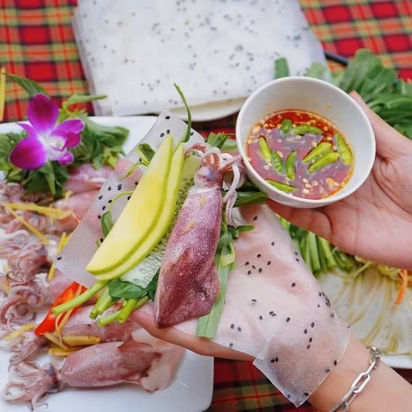 Mực sau khi làm sạch, bỏ túi mực và màng ngoài thì khứa nhẹ để thấm gia vị, ướp cùng muối, tiêu, gừng băm và bột ngọt khoảng 10–15 phút. Rau muống nhặt phần non, ngâm nước muối loãng rồi để ráo. Xoài xanh gọt vỏ, thái sợi dài. Hành lá rửa sạch, chẻ đôi đầu hành, cắt khúc phần lá. Tiếp đó, cho mực vào đĩa, rải gừng, hành tím, hành lá lên trên và đem hấp cách thủy khoảng 7–8 phút để mực vừa chín tới, giữ được độ giòn và vị ngọt tự nhiên. Ảnh Hà Nguyên