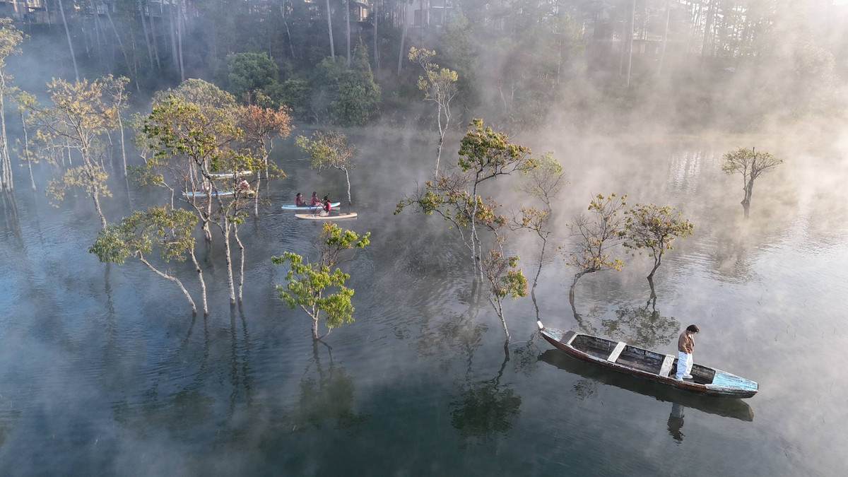 Khoảng thời gian cuối mùa thu và đầu mùa xuân được xem là lúc Suối Tía đẹp nhất trong năm. Khi ấy, rừng chò bước vào mùa thay lá, những cành cây trơ trụi mang sắc trắng ngà, điểm xuyết những chồi non xanh biếc. Thỉnh thoảng, hình ảnh ngư dân thả câu giữa làn sương sớm càng khiến khung cảnh thêm phần bình yên, thi vị. Ảnh Bảo Ân