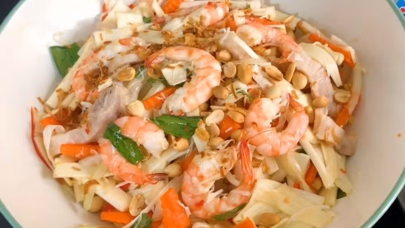 Mở đầu bữa cỗ thường là gỏi củ hủ dừa tôm thịt – món khai vị thanh mát, giòn ngọt. Củ hủ dừa được trộn cùng tôm luộc, thịt ba chỉ và nước mắm chua ngọt, điểm thêm đậu phộng rang. Vị tươi mát hòa quyện vị béo, tạo cảm giác nhẹ nhàng mà hấp dẫn.