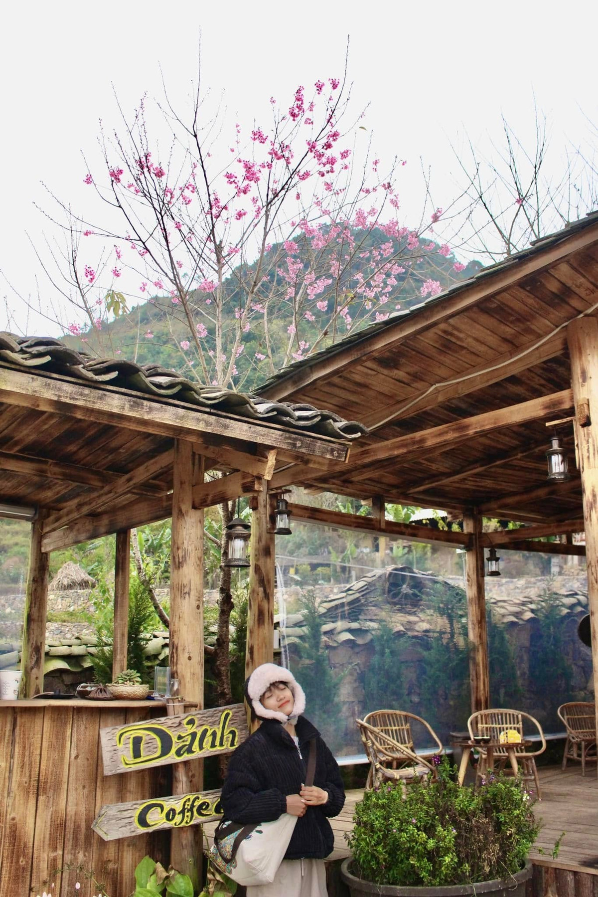 Đứng dưới những tán anh đào đang độ bung nở, phóng tầm mắt ra xa là hình ảnh Cột cờ Lũng Cú sừng sững giữa núi non. Lá cờ đỏ sao vàng tung bay trong gió, tạo nên điểm nhấn thiêng liêng giữa khung cảnh thiên nhiên thơ mộng – trải nghiệm khó quên với nhiều du khách khi đến vùng biên cương. Ảnh Kim Anh