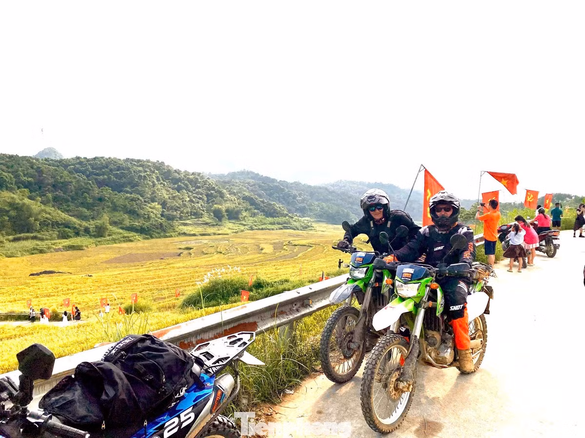 Từ giữa tháng 8, người dân địa phương bắt đầu treo cờ Tổ quốc dọc tuyến đường. Sắc đỏ nổi bật trên nền vàng óng khiến khung cảnh càng thêm rực rỡ. Nhiều du khách cho biết cảm giác xúc động khi nhìn thấy hình ảnh quen thuộc của quê hương hiện lên giữa núi rừng bao la. Ảnh Báo Tiền phong