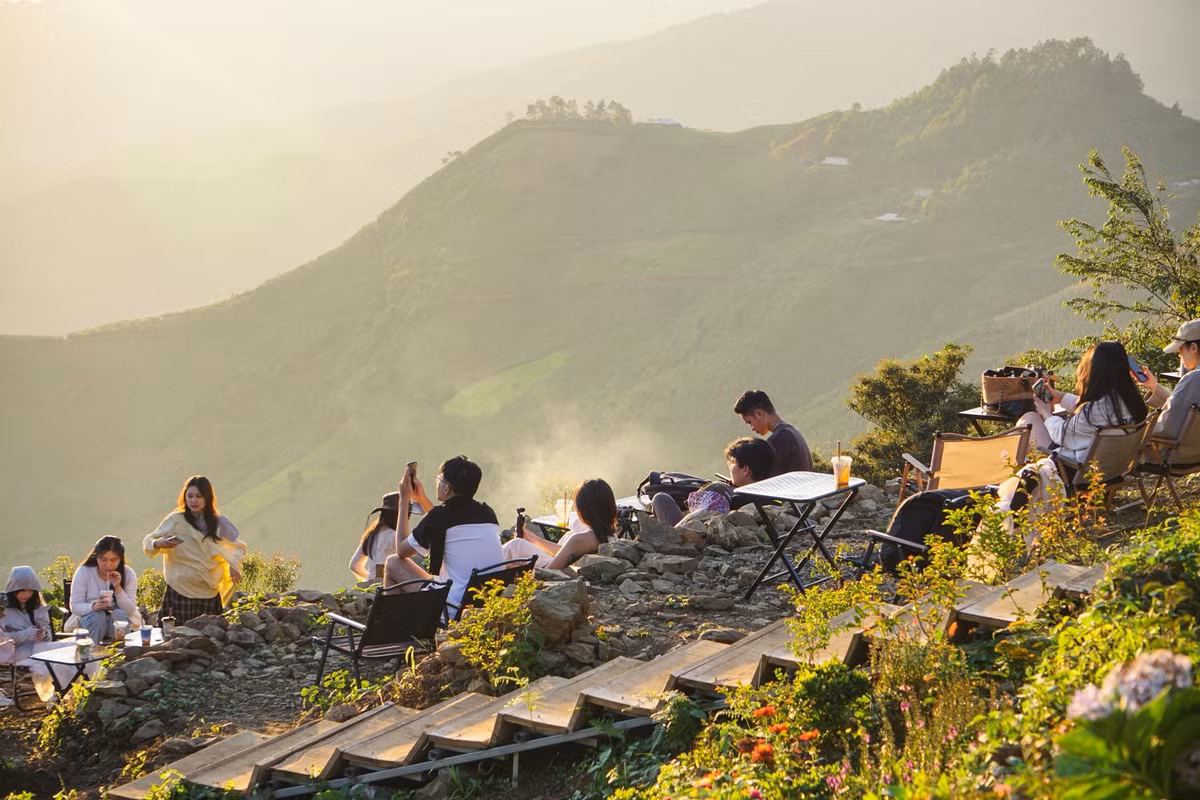 Chỉ một góc nhỏ trước quán cà phê Hoàng Hôn cũng đủ biến thành bức tranh sống động, nơi du khách vừa ngắm cảnh, vừa thả mình trong không gian yên bình giữa thiên nhiên. Ảnh Tiệm cà phê Hoàng Hôn