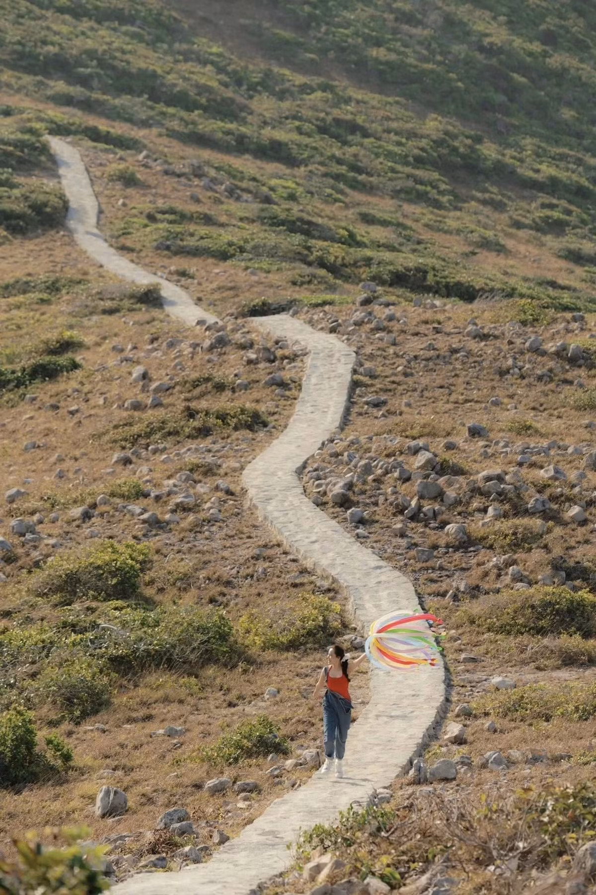 Điểm nhấn được nhiều người yêu thích là mỏm đá nhô ra vươn dài như “sống lưng khủng long”, nơi lý tưởng để ngắm toàn cảnh Côn Đảo từ trên cao. Từ vị trí này, vịnh Côn Sơn xanh biếc, những dãy núi bao quanh và thị trấn nhỏ nhắn hiện ra rõ mồn một dưới tầm mắt. Ảnh Nhi Ng