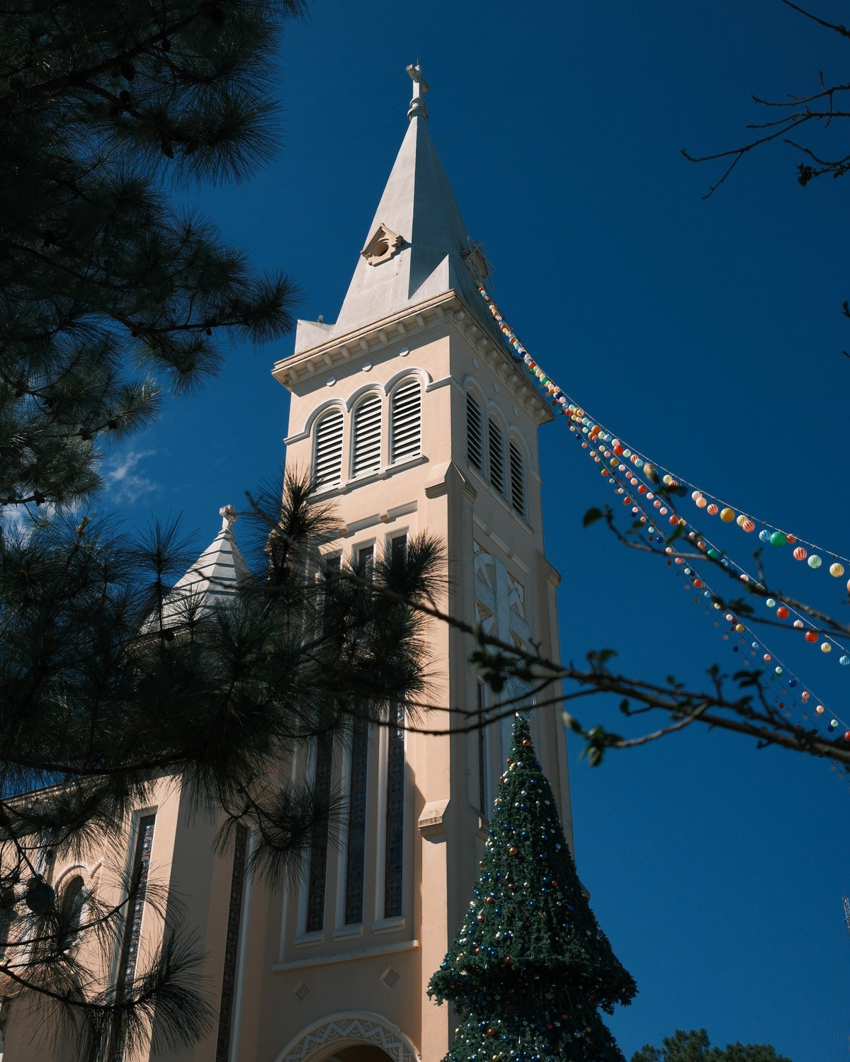 Bước vào khuôn viên nhà thờ, du khách dễ dàng cảm nhận được bầu không khí yên tĩnh, tách biệt hẳn với nhịp sống bên ngoài. Không gian bên trong mang vẻ trang nghiêm, với những hàng ghế gỗ sẫm màu, trần cao và hệ thống cửa kính màu đón ánh sáng tự nhiên. Khi ánh nắng len qua các ô kính, toàn bộ không gian như được phủ lên những mảng màu dịu nhẹ, tạo cảm giác an yên và sâu lắng. Ảnh thuan.jpeg
