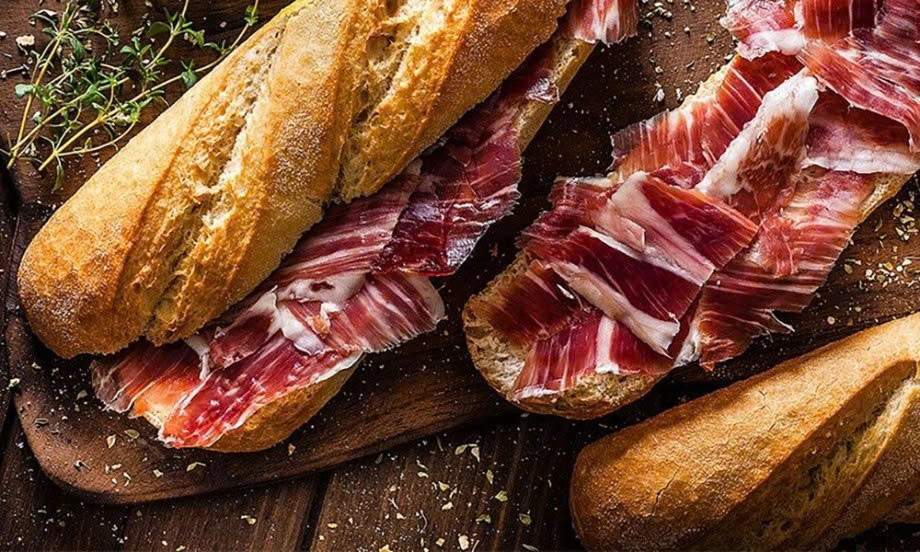 Không ít bữa bánh mì được kẹp cùng xúc xích, thịt nguội, pa-tê và các loại sốt nhiều dầu mỡ. Đây là nhóm thực phẩm chứa nhiều muối, chất béo bão hòa và phụ gia, có thể gây áp lực lên tim mạch, thận và hệ tiêu hóa nếu sử dụng thường xuyên. Ảnh minh họa