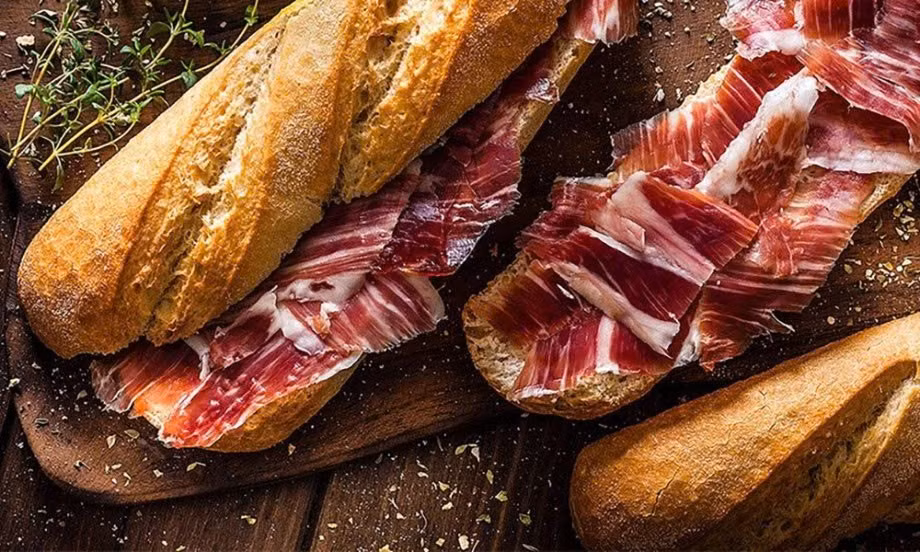 Không ít bữa bánh mì được kẹp cùng xúc xích, thịt nguội, pa-tê và các loại sốt nhiều dầu mỡ. Đây là nhóm thực phẩm chứa nhiều muối, chất béo bão hòa và phụ gia, có thể gây áp lực lên tim mạch, thận và hệ tiêu hóa nếu sử dụng thường xuyên. Ảnh minh họa