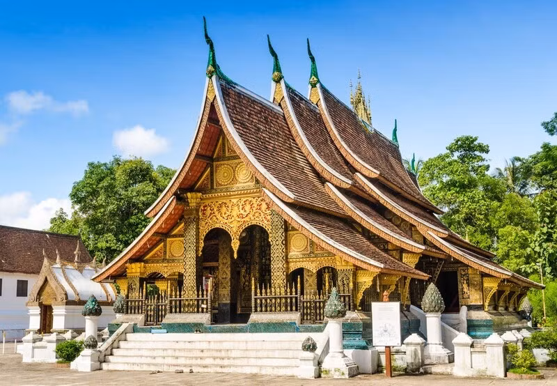 Tại thành phố di sản Luang Prabang, chùa Wat Xieng Thong được xây từ thế kỷ 18 với mái cong dài gần mặt đất, tường trang trí bằng các miếng ghép nghệ thuật kể chuyện Đức Phật, trở thành điểm đến hành lễ và chiêm ngưỡng kiến trúc đặc trưng văn hóa Lào. Ảnh datvietour