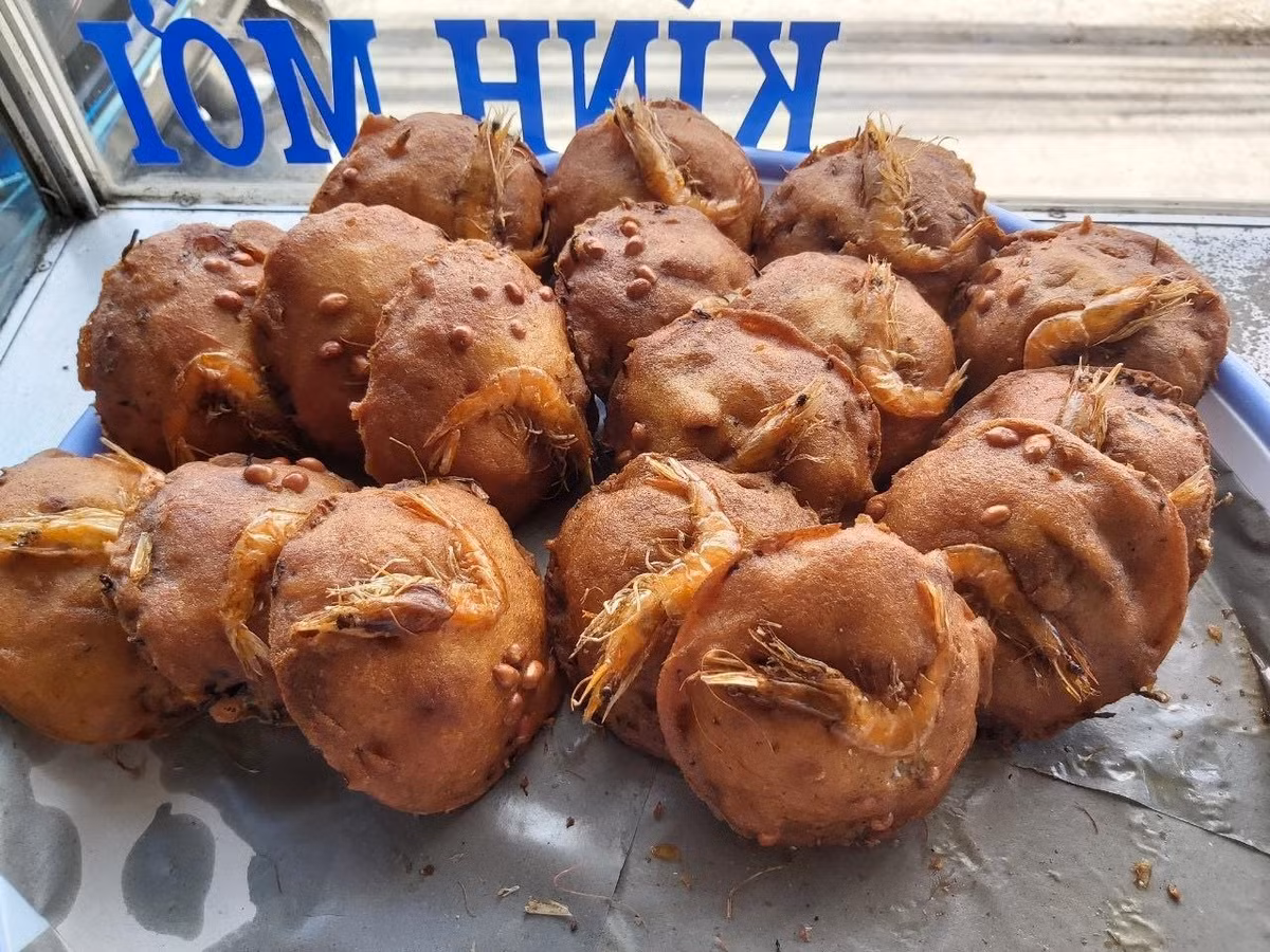 Chiếc vá được tráng qua dầu nóng để chống dính, sau đó múc hỗn hợp bột cùng topping rồi thả nhẹ xuống chảo dầu đang sôi. Khi bánh bắt đầu định hình, người làm khéo léo tách vá ra để bánh nổi lên, chín vàng ruộm.