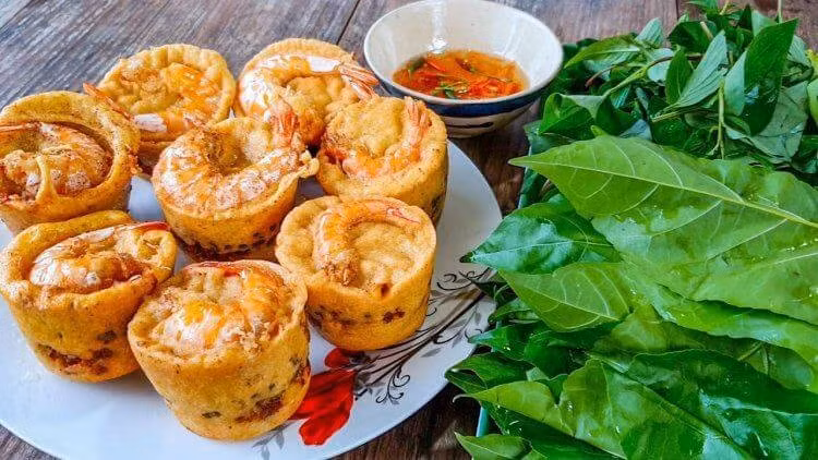 Tên gọi “bánh vá” bắt nguồn từ chiếc vá – muôi tròn có cán dài, thường được dùng trong bếp để múc canh hay chiên bánh. Khi người dân đổ bột vào vá, thêm topping rồi thả vào chảo dầu sôi, chiếc bánh sẽ dần chín vàng, tròn đều như mặt trăng rằm. Ảnh Cuộc sống miệt vườn