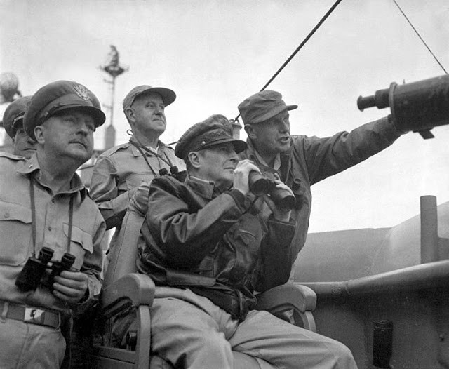 Tướng Douglas MacArthur (ngồi trên ghế) dùng ống nhòm quan sát cuộc pháo kích của lực lượng hải quân ở Incheon khi ở trên tàu sân bay USS Mt. McKinley ngày 15/9/1950.