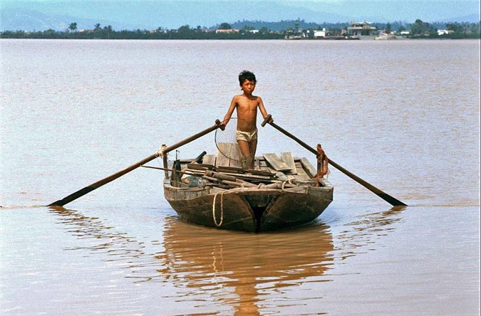 Cậu bé chèo thuyền trên sông Cấm.