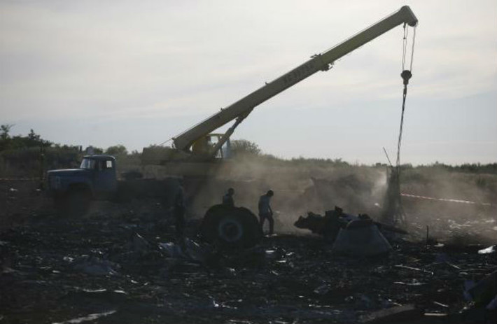 Nhân viên Bộ Khẩn cấp Ukraine dùng cần cẩu để di chuyển những mảnh vỡ máy bay MH17.
