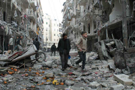 Một người già Syria dẫn đứa trẻ đi dạo trong một khu vực bị tàn phá do bom của trực thăng quân đội chính phủ Syria vào ngày 18/3/2014 ở Aleppo.