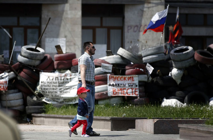 Hai cha con đi dạo bên ngoài tòa chị chính Donetsk.