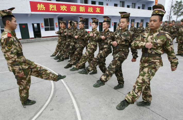 Chiến sĩ dân quân Trung Quốc tập giữ thăng bằng với mũ đặt ngược trên đầu.