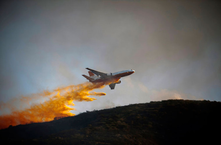 Máy bay DC-10 Super Tanker thả chất chống cháy xuống khu vực chưa bị cháy rừng ở gần thành phố San Marcos ngày 14/5.