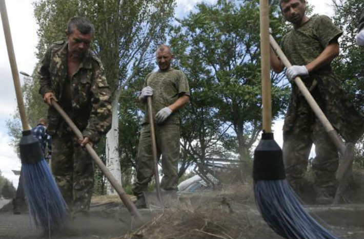 Các binh sĩ Ukraine - bị bắt giữ đang đi quét đường.