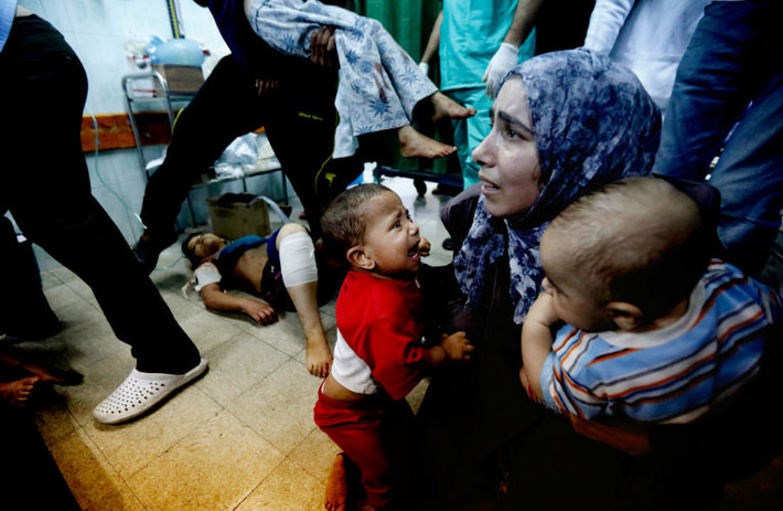 Một người mẹ trẻ ôm 2 đứa con trong bệnh viện ở dải Gaza sau cuộc pháo kích của Israel.
