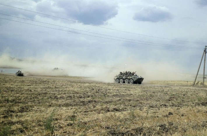 Binh sĩ Nga trên đoàn xe bọc thép di chuyển ở làng Krasnodarovka, gần biên giới Nga - Ukraine.