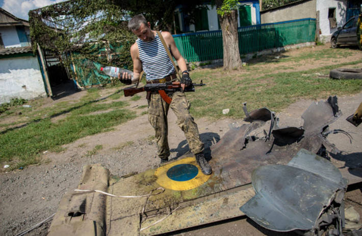 Phiến quân ly khai miền đông Ukraine đứng trên cánh của chiếc máy bay bị bắn rơi.