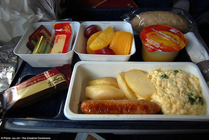 Bữa sáng dành cho khách đi vé hạng phổ thông trên một chuyến bay của hãng Delta Airlines từ London tới New York với trứng, xúc xích, salad trái cây và nước cam.