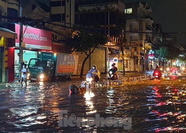 Nước ngập sâu mỗi khi có ô tô chạy qua tạo thành sóng tạt vào nhà dân khiến sinh hoạt, buôn bán bị ảnh hưởng.