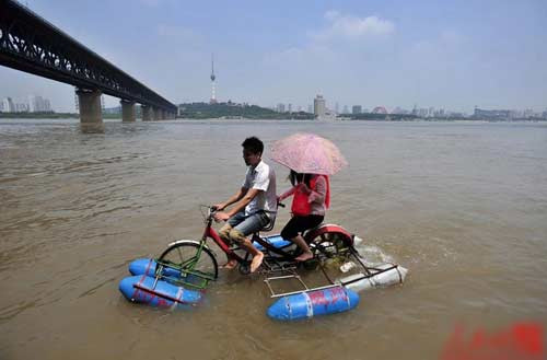 Xiao Lei và bạn gái du ngoạn bằng chiếc xe tự chế trên sông Dương Tử ngày 29/6/2011. Chiếc xe được chế tạo bởi thầy giáo của Xiao là Li Weiguo. Nó là phương tiện đi lại ở cả đất liền và trên sông.