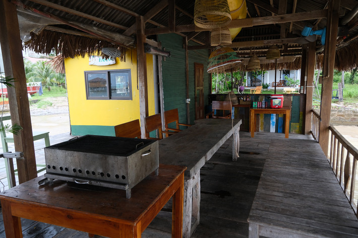 Bên trong một bungalow với nhiều bàn ghế, lò nướng phục vụ hoạt động kinh doanh.
