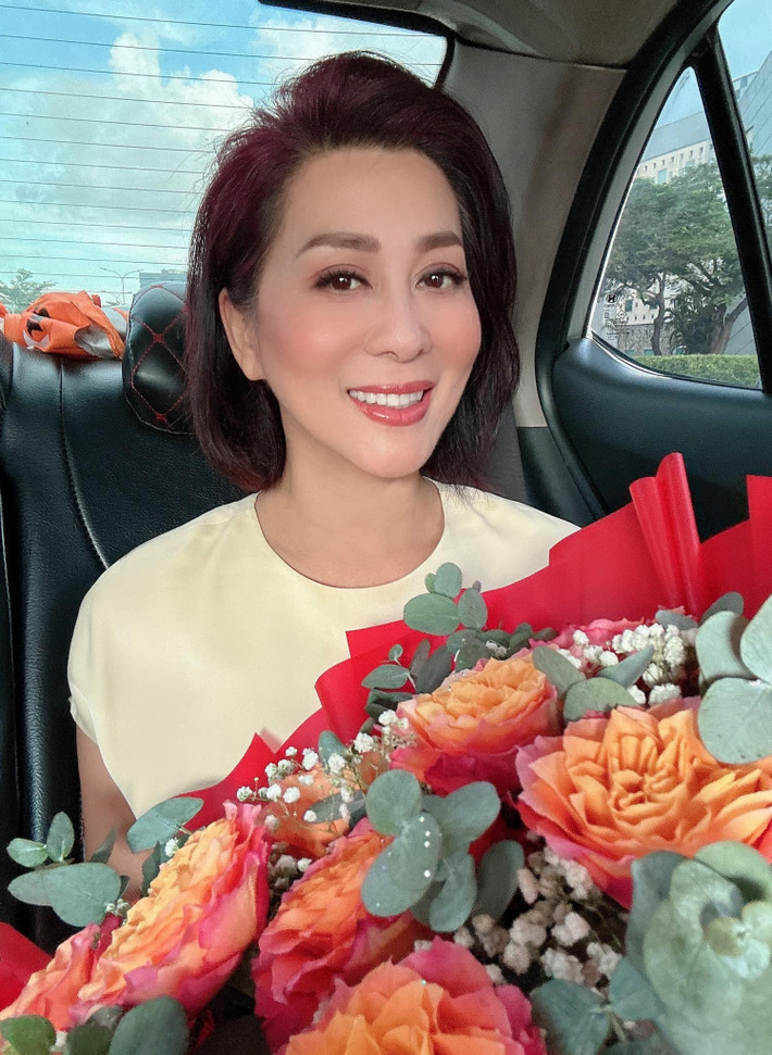 Sao Việt ngày 6/10: Trong phong cách trang điểm nhẹ nhàng, MC Kỳ Duyên trẻ trung, xinh đẹp dù ở tuổi U60. Cô khoe bó hoa đẹp vừa được tặng.