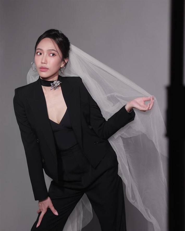 iểm nhấn cho bộ suit này là chiếc áo 2 dây xẻ ngực khá sâu bên trong cùng chocker đính hoa hồng kim loại.