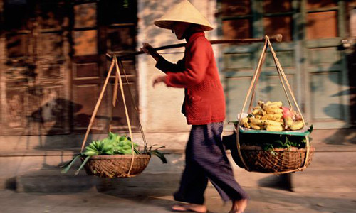 Hình ảnh bà lão với gánh hàng rong trên vai bán những mặt hàng như rau, quả... tại phố cổ Hội An. Bức ảnh này do Gavin Hellier chụp.