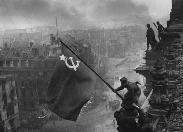 Binh sĩ vẫy cờ Liên Xô trên đỉnh một tòa nhà ở Reichstag, Berlin, Đức năm 1945.
