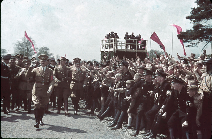 Đám đông đứng hai bên đường chào đón Hitler khi trùm phát xít tham dự buổi lễ tại nhà máy Volkswagen năm 1938.