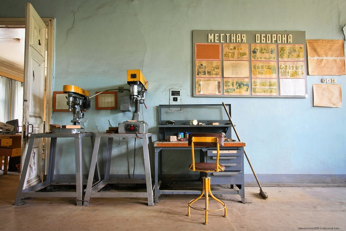 Một căn phòng trong khu hỗn hợp với bàn ghế và một số thiết bị quân sự bị bỏ lại.