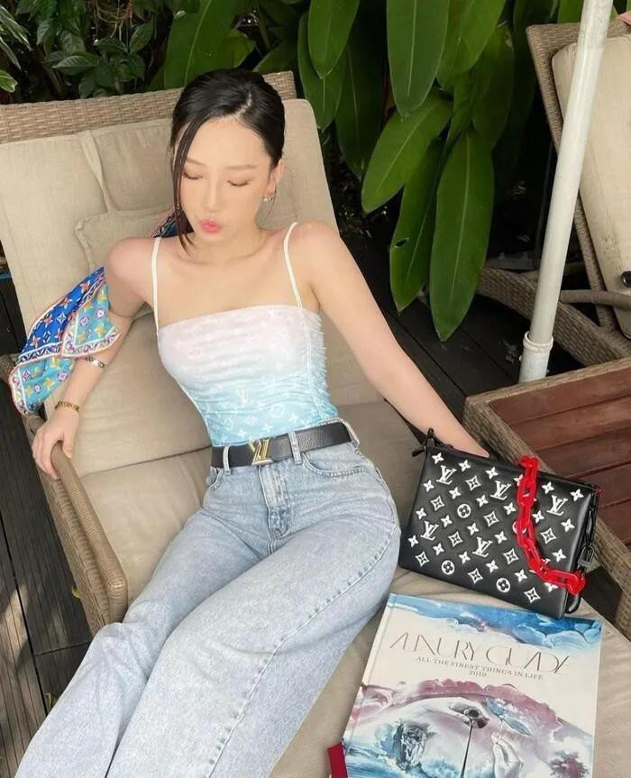 Amee phủ hàng hiệu với áo hai dây mix quần jeans suông và túi Louis Vuitton.