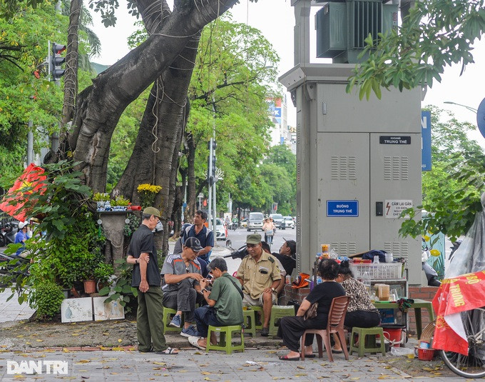 Ghi nhận của phóng viên Dân trí, dọc các tuyến đường, phố của Hà Nội như Giải Phóng, Trần Khát Chân, Hồ Tùng Mậu, Cầu Giấy... không khó bắt gặp cảnh người dân vô tư ngồi ăn, uống, bán hàng, mưu sinh sát cạnh các trạm biến áp, bốt điện.