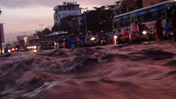 Theo người dân, khi cây ngã xuống, cành lá đè vào chiếc xe máy dựng trên vỉa hè. Khoảng 16h, một cây bàng nằm trước số nhà số 32 đường Văn Thân, P.8, Q.6 đã gãy ngang thân rớt xuống đường khiến tình trạng kẹt xe kéo dài. Trong ảnh là sóng nước trên đường Kinh Dương Vương dâng tới gần thắt lưng.
