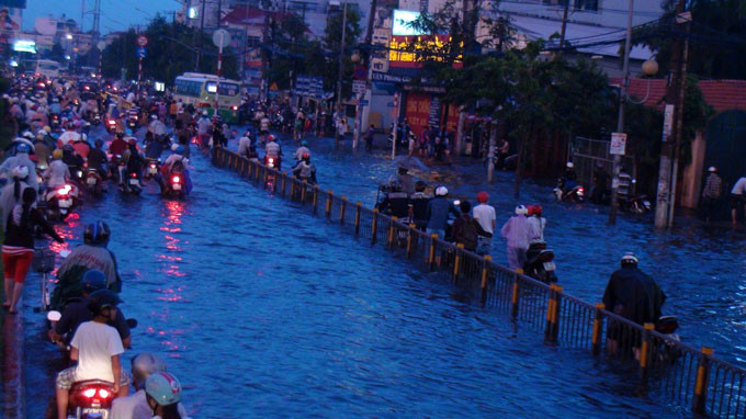 Còn tại đường Kinh Dương Vương đoạn ở P.An Lạc, Q.Bình Tân, nước ngập đến đầu gối khiến hàng ngàn xe cộ băng qua đoạn đường này bị chết máy. Mỗi khi ôtô chạy qua, từng đợt sóng nước dâng lên xô ngã người đi đường.