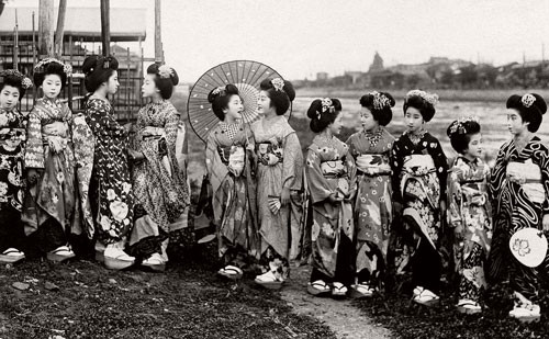 ##sc### Một nhóm các cô gái Maiko đứng bên bờ sông chơi đùa.