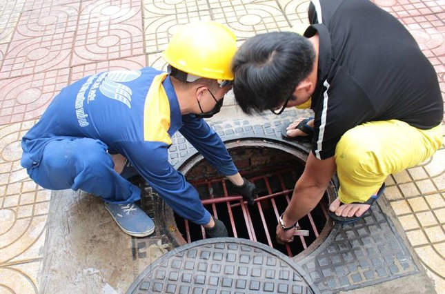 Cửa xuống hầm được bố trí 2 lớp, gồm lớp tấm nắp gang bên trên và tấm lưới sắt có khóa bảo vệ bên dưới.