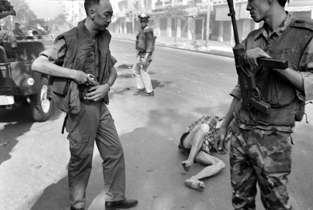 Nói về bức ảnh trên, Eddie Adams kể lại: “Tôi dõi máy theo ba người đó, chụp một kiểu ảnh. Khi họ đến gần - cách khoảng 1,5m, những người lính dừng lại và lui về phía sau. Tôi thấy một người đàn ông từ bên trái bước vào trong vùng ngắm máy ảnh của tôi. Ông ta rút một khẩu súng lục ra khỏi bao và nâng lên".